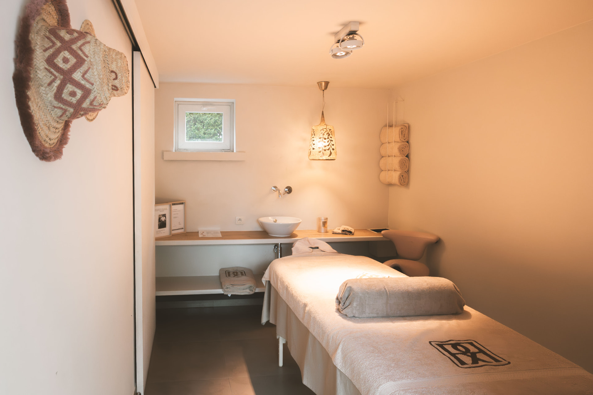 Behandelruimte met massagetafel, waskom en handdoeken